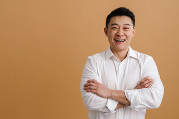 Brunette adult asian man smiling at camera standing with arms folded