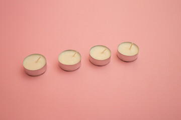 Candles with white wax on a pink background