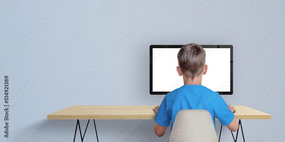 Poster Boy learn to code on desktop computer concept. A boy in a blue shirt with his back turned. Copy space aside. Isolated computer display for page promotion
