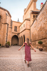 Fototapeta na wymiar Blonde girl walking in a medieval castle, enjoying the holidays