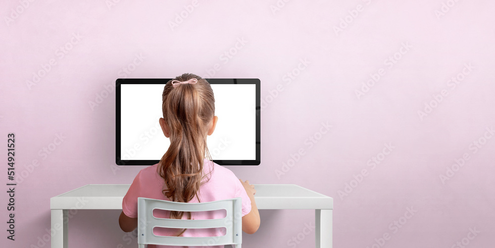 Poster Girl sitting on a chair and working on the computer. Isolated computer display for design promotion. Pink wall with copy space