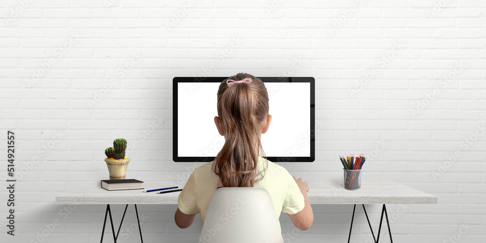 Poster Girl is studying and working on the computer. The concept of using modern technologies for children. Work desk in the room with books and pens