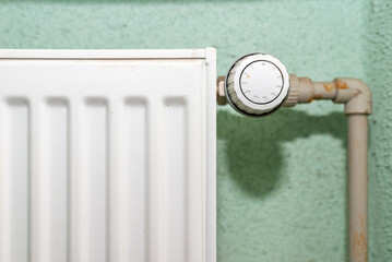 Old white radiator thermostat with copy space,closeup,selective focus,green background.