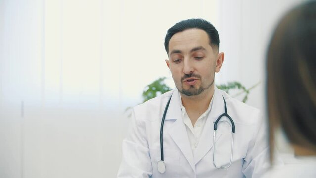 4k slow motion video of doctor wearing white lab coat holding explaining.