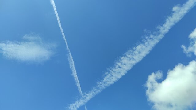 Abstract Defocused traces of clouds from two planes passing in a clear blue sky in the Cicalengka area, Indonesia