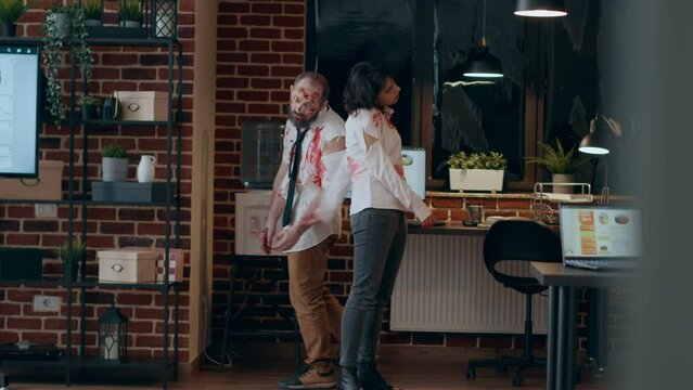 Creepy dangerous looking zombies wandering inside office workspace. Brain dead spooky walking dead corpses with bloody and deep scars and wounds running to camera when they observe it.
