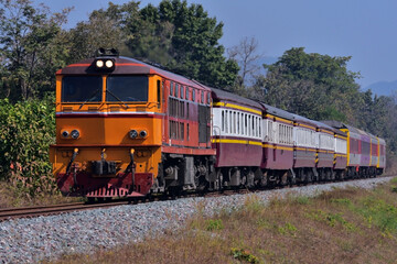 Fototapeta na wymiar Thai passenger train by diesel locomotive on the railway.