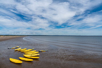 many sea kayaks and paddleboards on the beach of St. Andrews in Scotland