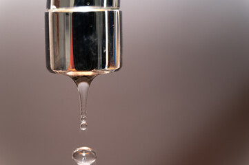 Tap from which drops of water flow. Drought, shortage, rationing and proper use of water.
