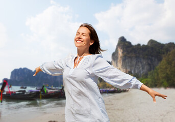 travel, tourism and vacation concept - happy smiling woman over tropical beach background in french polynesia