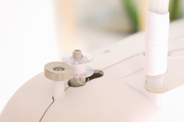 Winding threads on a bobbin on a sewing machine.