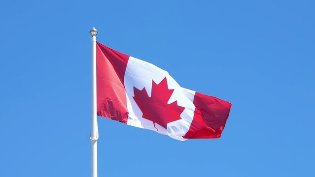Canadian flag waving against blue sky