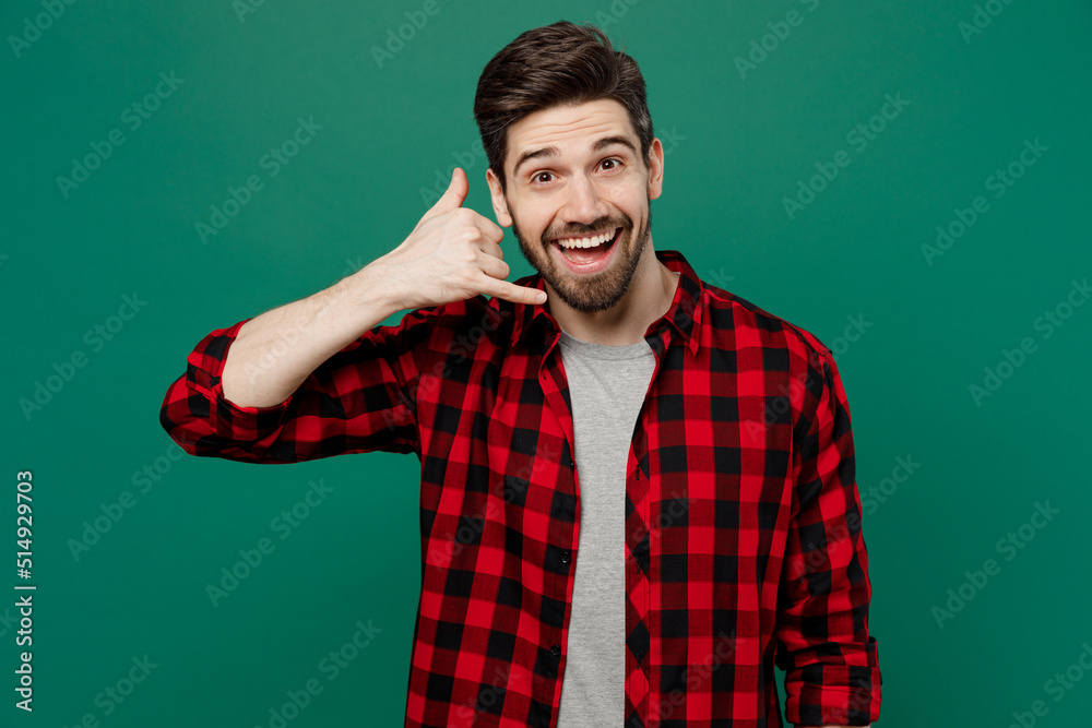 Wall mural Young happy smiling fun caucasian man he 20s wearing red shirt grey t-shirt doing phone gesture like says call me back isolated on plain dark green background studio portrait People lifestyle concept.