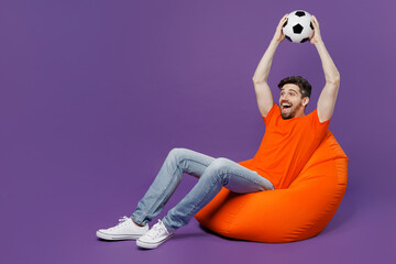 Full body excited young fan man he wear orange t-shirt cheer up support football sport team hold...