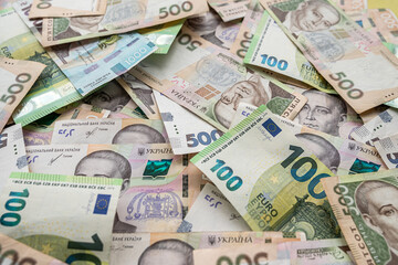 Obraz na płótnie Canvas Top view of various euro and Ukrainian hryvnia banknotes on a spacious table.