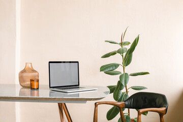 Modern minimalistic office interior. Laptop with blank screen on table.