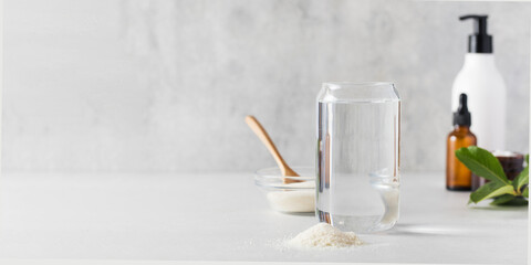 A glass of water, a slide of collagen powder, care cosmetics. Anti-aging procedures, nutritional supplements for healthy