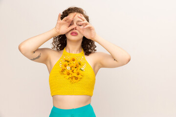 Young sensual girl in avant-garde style blue-yellow outfit isolated over white background. Vivid...