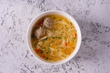 noodle soup with meatballs on a light concrete background