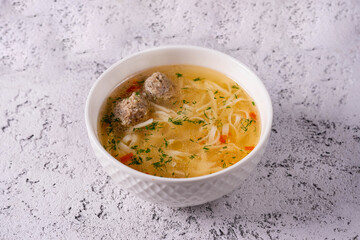 noodle soup with meatballs on a light concrete background