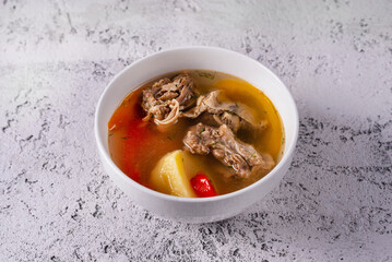 Shurpa soup with meat. on a light concrete background