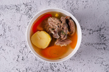 Shurpa soup with meat. on a light concrete background