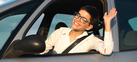 Young businesswoman driving car on a sunny summer day