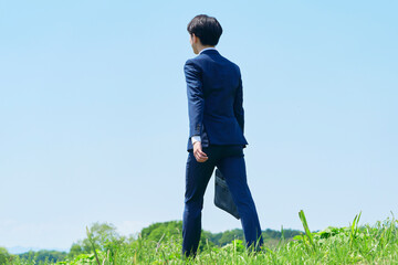 屋外を歩くビジネスマンの後ろ姿