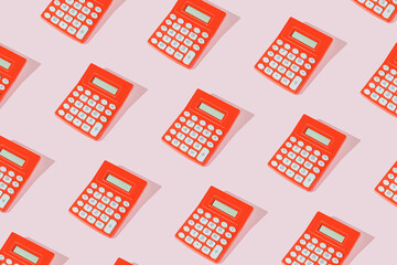 Modern pattern with vintage red calculators on sunny pink table.