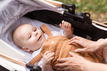 Photo of sweet cute mom small daughter wear casual outfits walking riding baby carriage outside...