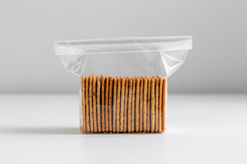 food, eating and snacks concept - close up of salted cookies or crackers in zip lock bag on white background
