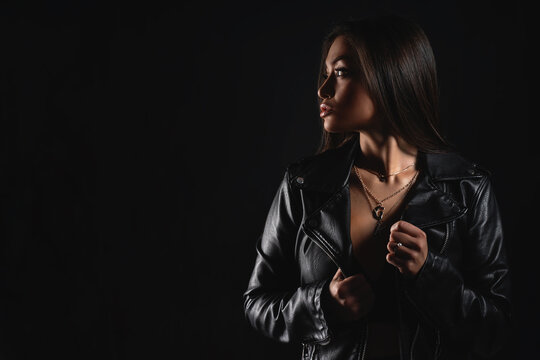 Profile photo of a stylish girl in a biker jacket with massive jewelry around her neck. Copy space