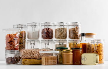 food storage and eating concept - close up of different cereals, groceries and preserves on table