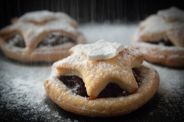 Christmas stars cookies on a dark background, close up with, snowfall effect