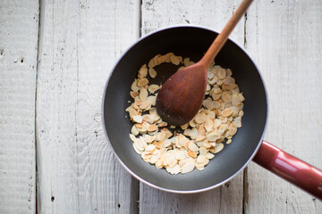 Almonds to fry in a pan on the stove. Top view.