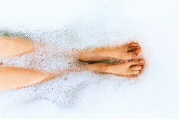 Bath time. Top view of the female feets in the bathtub. Human body care concept