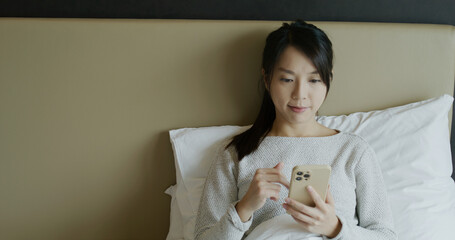 Woman use mobile phone on bed