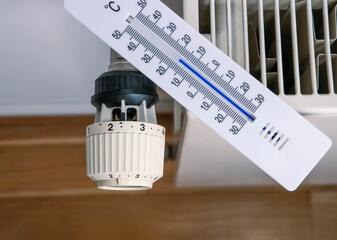 Thermometer lies on a radiator to measure the room temperature