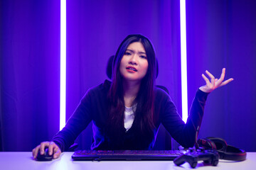 Fototapeta na wymiar Stressed Boring Young pretty asian woman playing game computer pc. Chinese female Gamer with keyboard playing video game at home feeling sadness. Loss and Missed the chance to become a champion