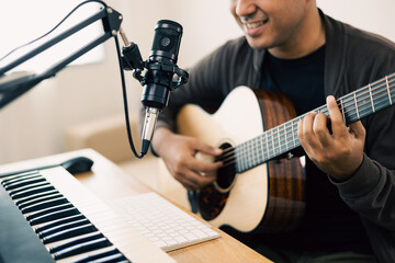 Close up hands songwriter playing acoustic guitar in home studio. Professional musician with audio...