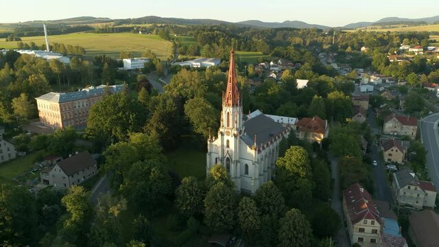 Drone look to gothic revival style Catholic church in small town Chrastava in the North of the Czech Republic during sunset