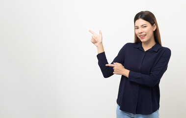 Young beautiful woman pointing finger to copyspace. Happy cheerful female on isolated white background. Pointing to blank space for advertise text.