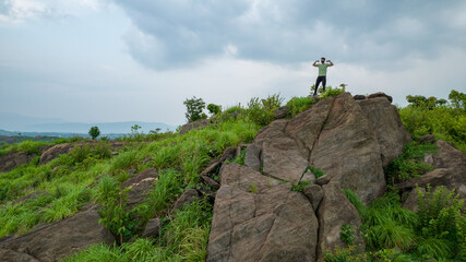 Man climbing up hills, feeling strong and powerful, self improvement, success, and life goals concept.