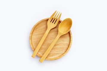 Wooden plate with spoon and fork on white