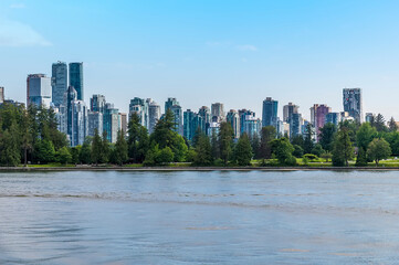 A view from the bay across Stanley Park towards the skyline of Vancouver, Canada in summertime