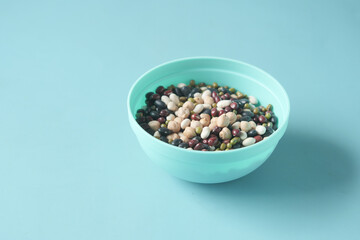  mixed beans in a bowl on light green background 
