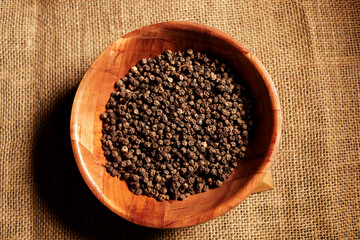 Black peppercorn in wooden bowl