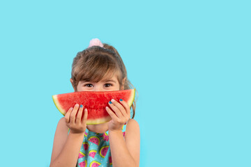 Girl eating watermelon on blue background. Copy space