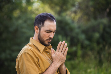 The man is praying. Prayer to God. A man on the street prays for world peace. Prayer. Faith and religion.
