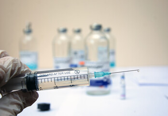 Naklejka premium syringe with a drop of medicine on the needle close-up. injection, syringe close-up
